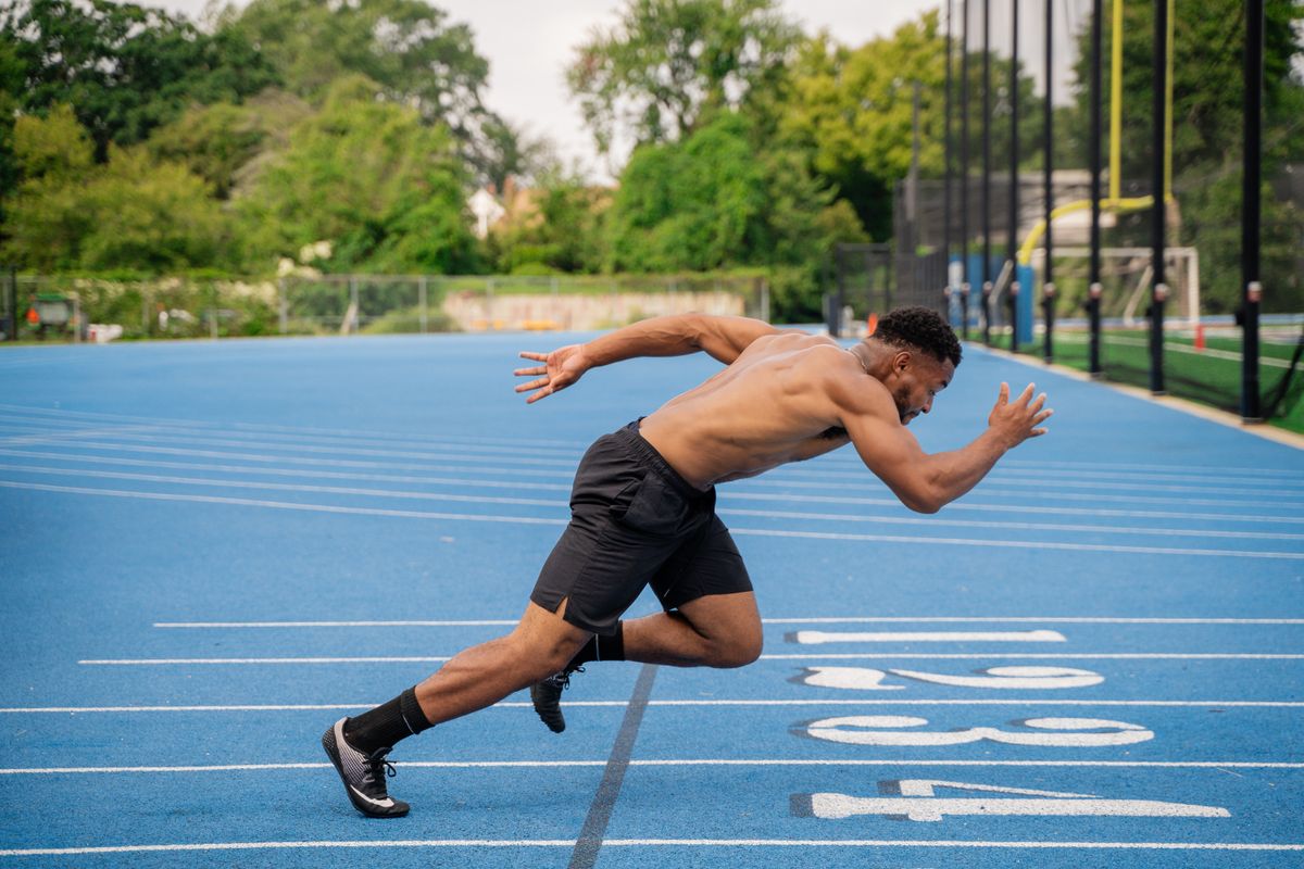 Homem correndo em pista de atletismo